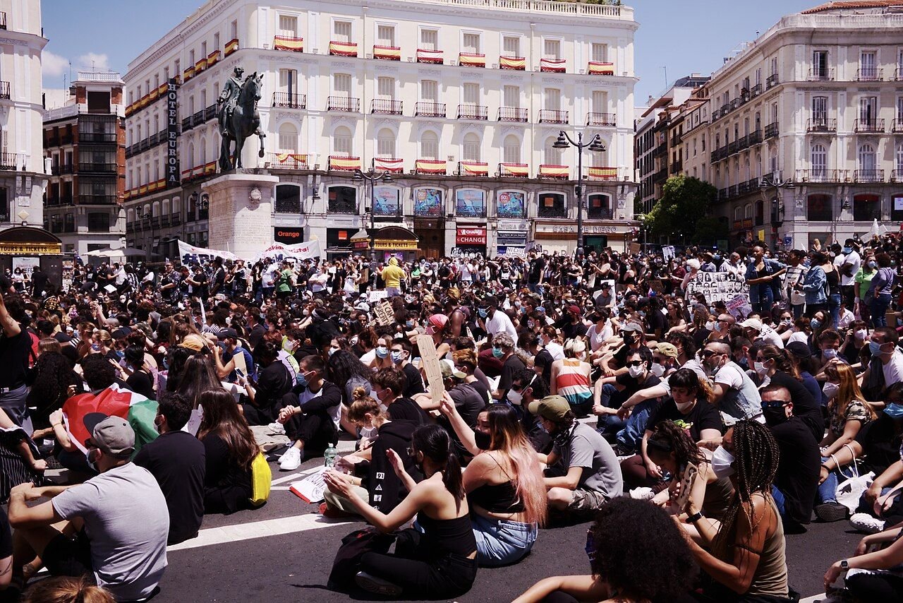 Cientos de personas sentadas en la Puerta del Sol en una concentración contra el racismo