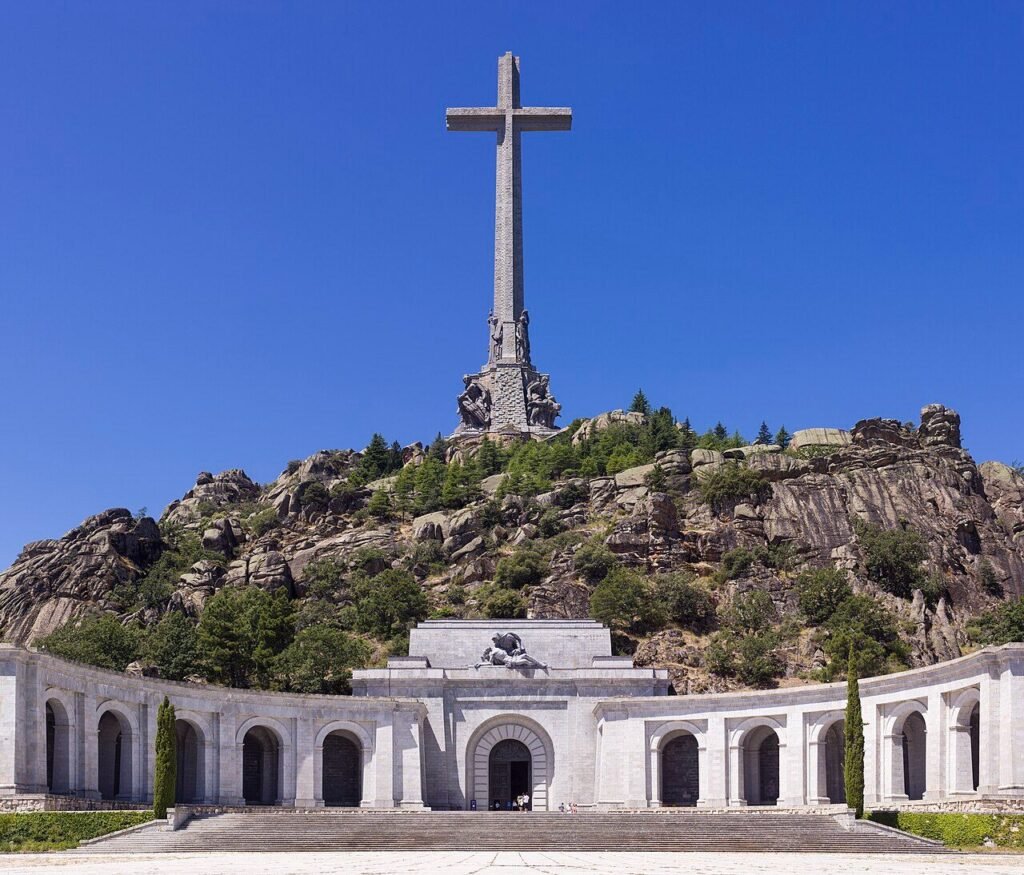 Vista frontal del conjunto de Cuelgamuros, con la gran cruz de piedra sobre el risco y la explanada con la columnata