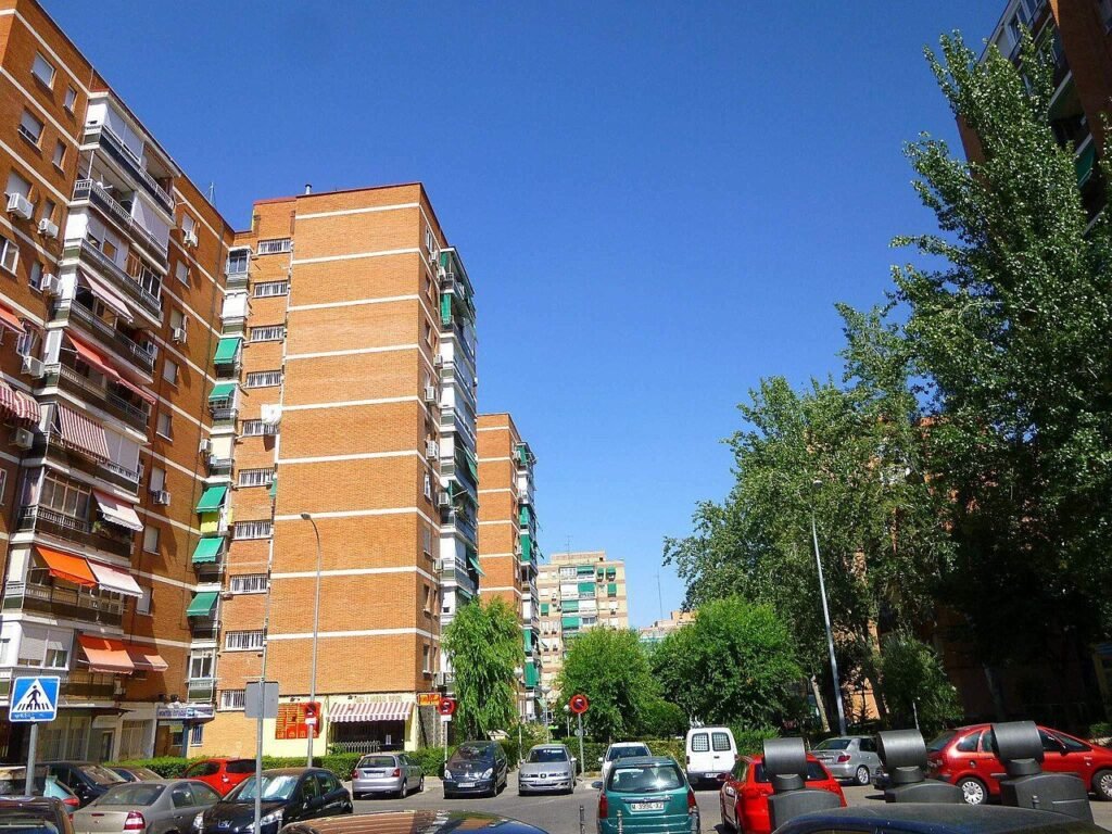 Bloques de viviendas de ladrillo en el barrio de Zarzaquemada, en Leganés, con árboles y coches aparcados