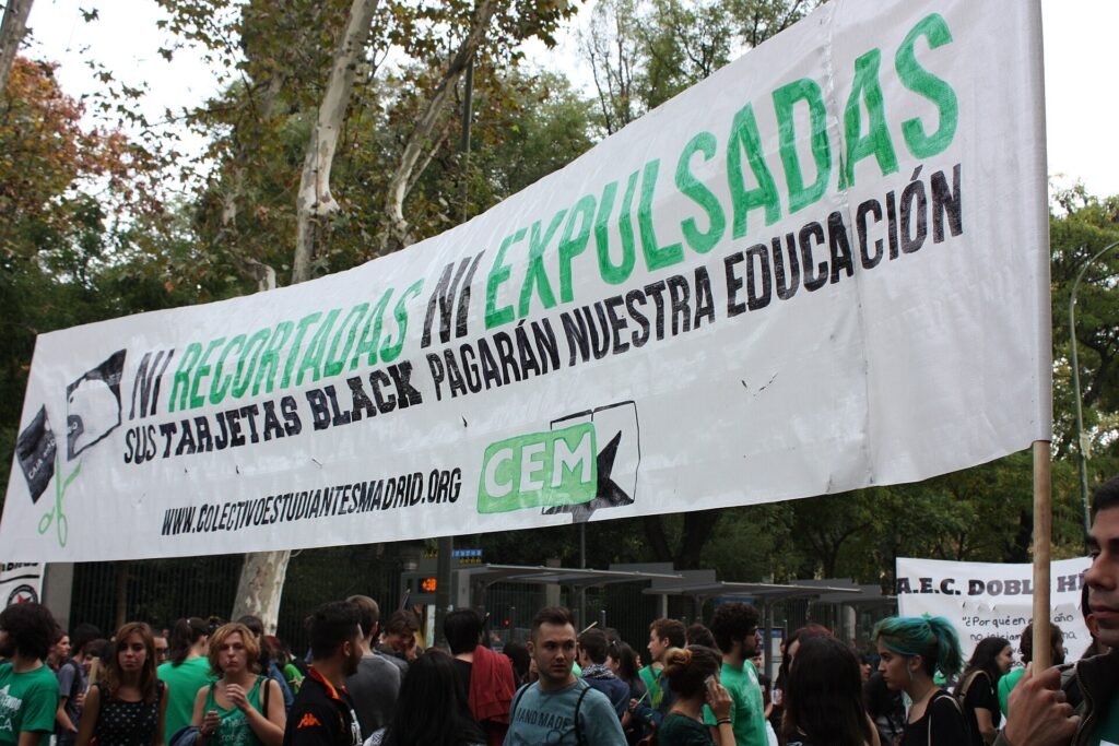 Estudiantes tras una pancarta verde en defensa de la educación pública en Madrid